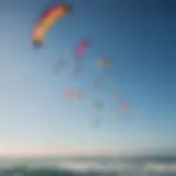 An assortment of kitesurfing kites in vibrant colors against a clear sky