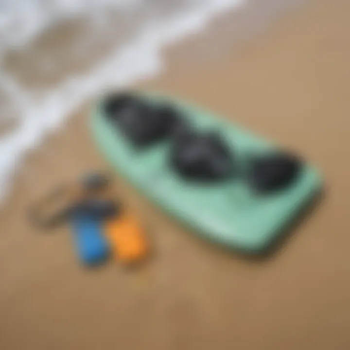 Close-up of essential boogie boarding equipment laid out on the sand.