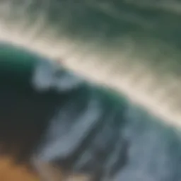 Aerial view of surfers riding waves at sunset