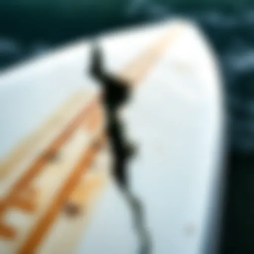 Detailed view of a cracked fiberglass surfboard