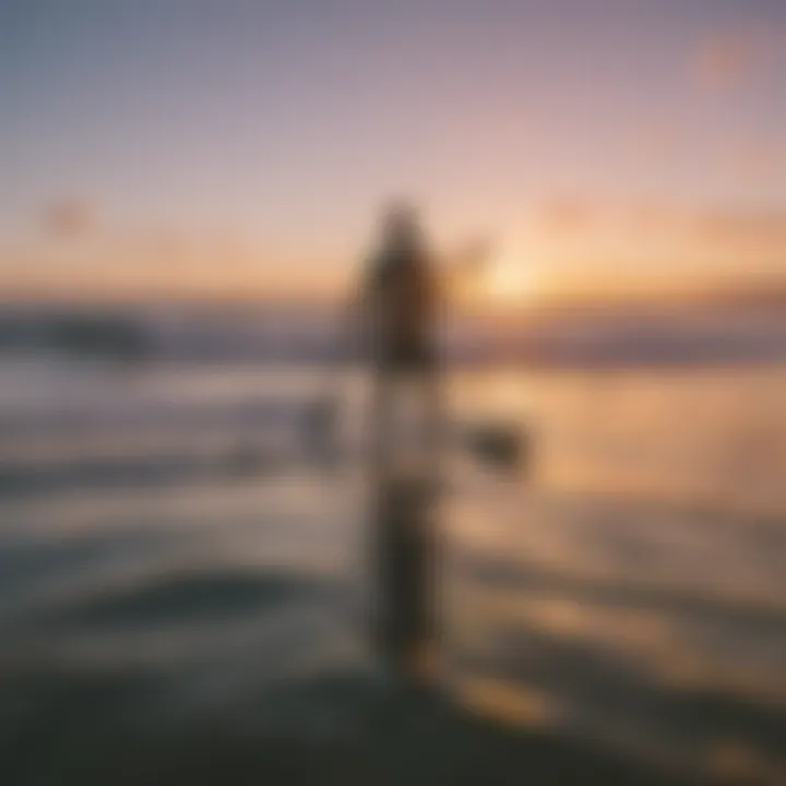 Surfer paddling out into the ocean under a colorful sunset