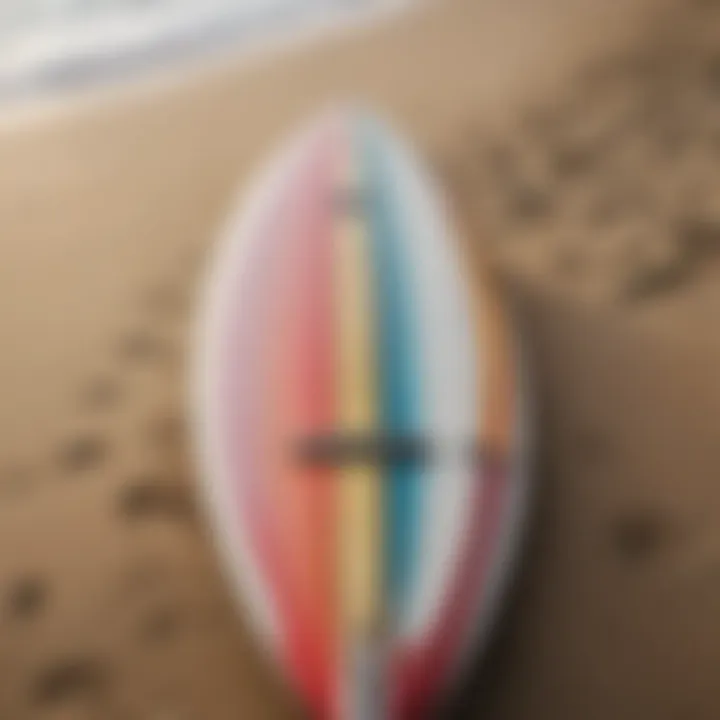 A close-up of a surfboard resting on the beach, showcasing its vibrant design