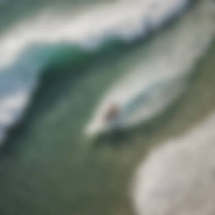 An aerial view of skimboarders riding waves on a beach