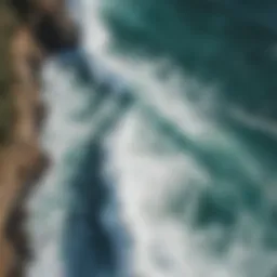 A stunning aerial view of ocean waves crashing against a rocky coastline